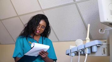 médico examina el embarazada del paciente médico historia. africano americano médico con un cuaderno en moderno hospital. concepto de medicamento, salud cuidado y personas video