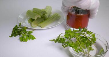 glasögon av tomat juice på en vit tabell. de hand sätter en glas av tomat juice på de tabell. friska och vegetarian mat begrepp. ultra 4k video