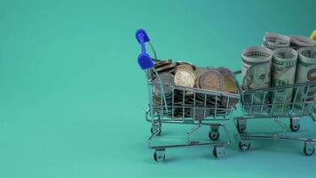 Animation. Shopping Carts carry coins and banknotes. Blue background. Finance and business concept. Close-up. 4K video