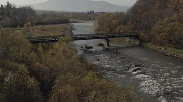 vecchio ferrovia ponte al di sopra di un' fiume. fuco volo al di sopra di ponte di vecchio stretto valutare ferrovia video