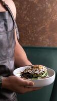 A plate of waffles and salmon with eggs in the hands of a waiter in the leather apron photo