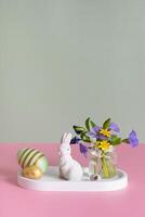 White rabbit, flowers and Easter eggs on a pink background and Easter eggs. Easter still life composition. photo