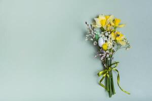 Easter spring bouquet with daffodils and willow on green background with copy space photo