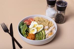 A plate with eggs, vegetables, couscous and meat on beige background angle view photo