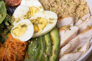 Close up plate with eggs, meat, vegetables and couscous top view photo