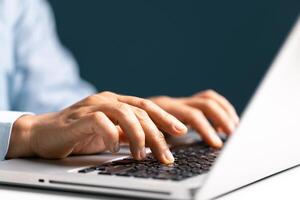 Businesswoman hand typing on laptop computer while working in white modern office room. photo