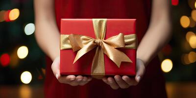 AI generated Woman hands holding a luxury gold red gift box with bow against a festive background, Xmas and New photo