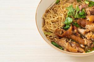 Stewed pork leg noodles in brown soup photo