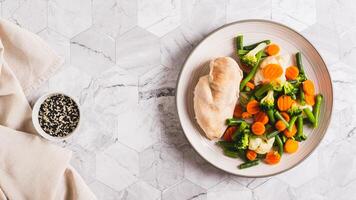 Boiled assorted vegetables and chicken fillet for diet food on a plate top view web banner photo