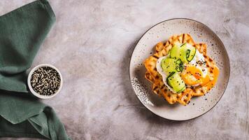 Waffles with poached egg, cucumber and sour cream on a plate on the table top view web banner photo