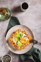 Waffles with poached egg, cucumber and sour cream on a plate on the table top and vertical view photo