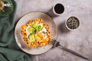 Toasts with cream cheese, cucumber, poached egg and sesame seeds on a plate top view photo