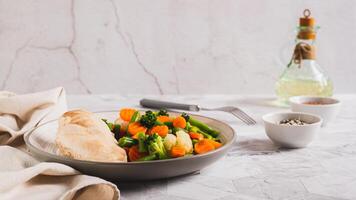 Mixed vegetables and steamed chicken breast on a plate on the table web banner photo