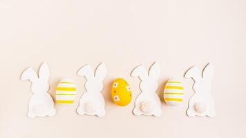 Happy Easter white decorative bunnies and easter eggs on pink background top view web banner photo