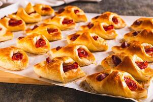 Homemade envelopes with cheese and pepperoni sausage on paper on a board photo