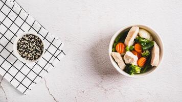 Diet soup with chicken fillet and boiled vegetables in a bowl on the table top view web banner photo