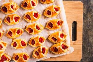 Homemade envelopes with cheese and pepperoni sausage on paper on a board top view photo