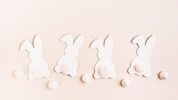 Happy Easter white decorative bunnies and mini meringues on pink background top view web banner photo