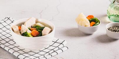 Homemade soup with chicken, cauliflower, broccoli, carrots and green beans in a bowl web banner photo