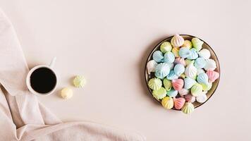 Sweet small meringues for dessert on a plate on the table top view web banner photo