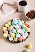Sweet small meringues for dessert on a plate on the table vertical view photo