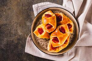 Close up of envelopes with cheese and pepperoni sausage on a plate on the table top view photo