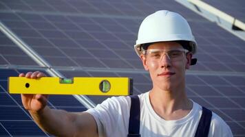 jung Ingenieur Installation Neu sonnig Batterien. Arbeiter im ein Uniform und Helm Installation Photovoltaik Paneele auf ein Solar- Bauernhof. das Zukunft ist heute video