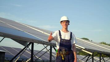 solar painel técnico trabalhando com solar painéis. feliz jovem homem mostrando classe em fundo do solar painéis. a futuro é hoje video