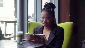 grave africano mujer distancia estudiante en línea conferencia en tableta comunicar por vídeo llamada video