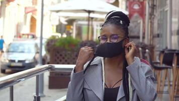 African american girl removes a medical mask. Back at work with social distance precautions. End of quarantine video