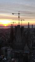 verticaal video van sagrada familia kathedraal, in Barcelona Bij zonsopkomst antenne visie