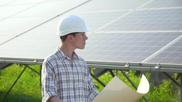 ingeniero en un blanco casco es a el solar poder estación. verde energía concepto video