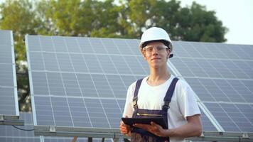 solaire panneau technicien travail avec solaire panneaux. ingénieur dans une uniforme avec une tablette chèques solaire panneaux productivité. le vert énergie concept video