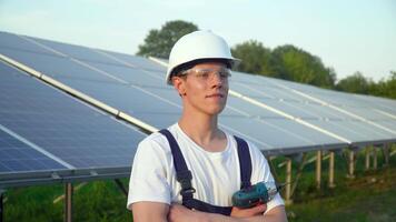 Engineer in a special equipment with screwdriver is at the solar power station. Concept renewable energy video