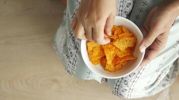 Dames hand- plukken aardappel chips van een kom video