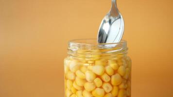 spoon pick sweet corn from a container video