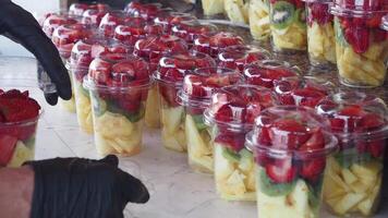 pineapple, kiwi and Strawberries in. plastic container selling at shop video