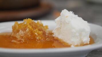 butter cream and honey in a bowl on table . video