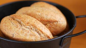 Three bread rolls rest in a black bowl on the table video