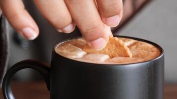 Gießen süße Kekse in eine Kaffeetasse auf Holztisch video