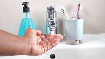 young man washing hands with soap warm water video