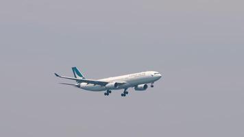 PHUKET, THAILAND - FEBRUARY 27, 2023. Airplane Airbus A330, B-LAK of Cathay Pacific approaching efore landing, side view. Airplane in the sky video