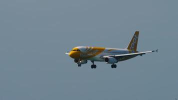 PHUKET, THAILAND - NOVEMBER 27, 2019. Airbus A320, 9V-TAN of SCOOT approaching before landing at Phuket airport, side view. The plane is flying. Travel concept video