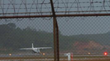 Small airplane speeding up before takeoff, rear view, view through the fence video