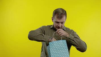 Man showing Up To 70 percent Off inscription from shopping bag, rejoicing discounts, low prices video