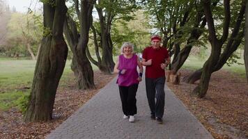 Sporty mature couple family jogging together. Senior husband and wife doing cardio workout exercises video