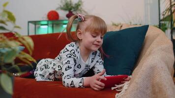 inquiet adolescent enfant fille enfant avec enthousiasme en jouant courses vidéo en ligne Jeux sur téléphone intelligent à Accueil video