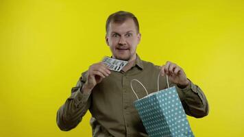 Man showing Black Friday inscription from shopping bag, smiling, rejoicing discount, low prices video