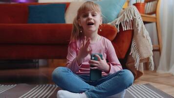 aufgeregt erstaunt Gewinner Kind Mädchen verwenden Handy, Mobiltelefon Telefon sagen Beeindruckend Ja erziehen Hände im Überraschung allein beim Zuhause video