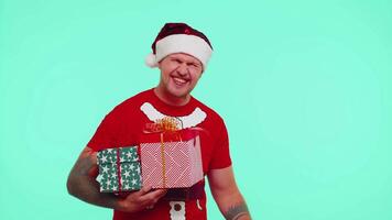 homme dans Noël T-shirt montrant cadeau des boites et 30 pour cent remise les inscriptions bannière texte Remarque video
